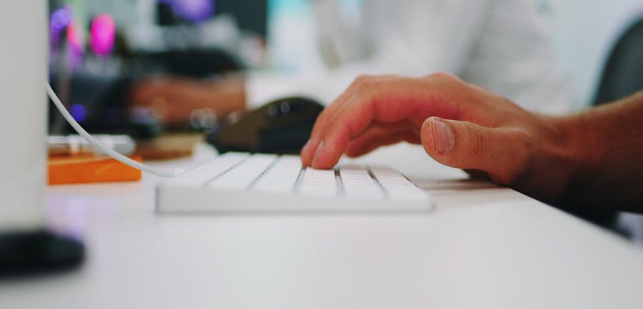 Closeup photo of a hand on a white keyboard