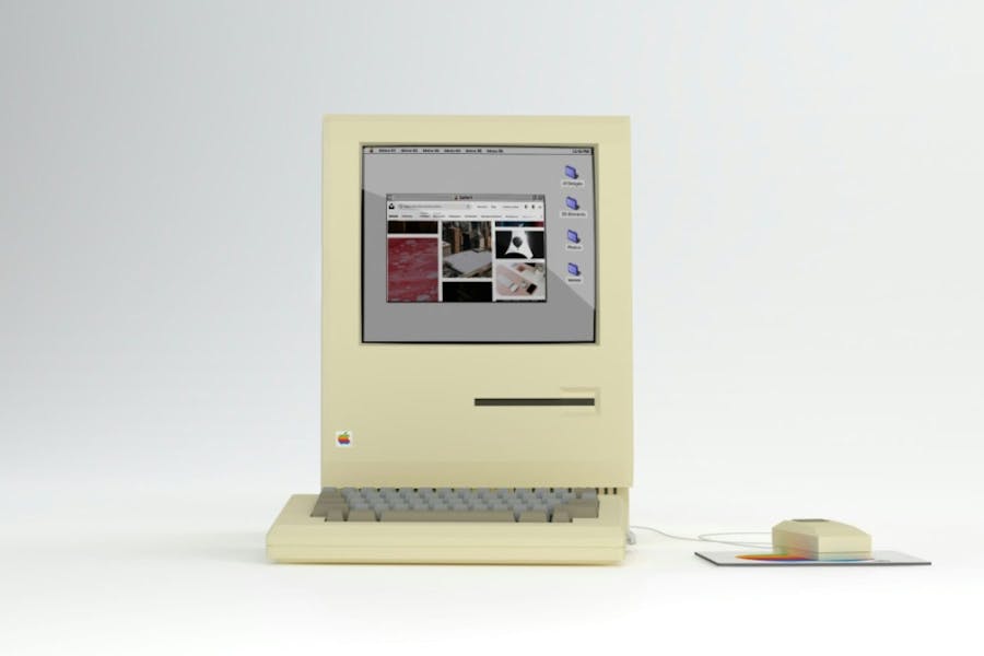 An old Apple computer and wired mouse on a white background