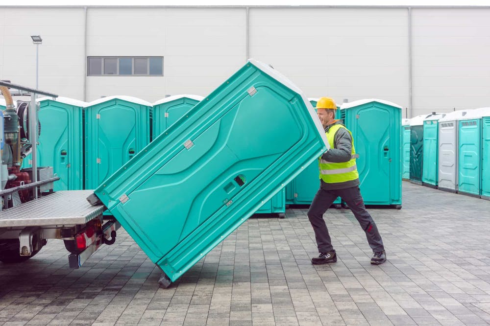 Man unloading porta potty